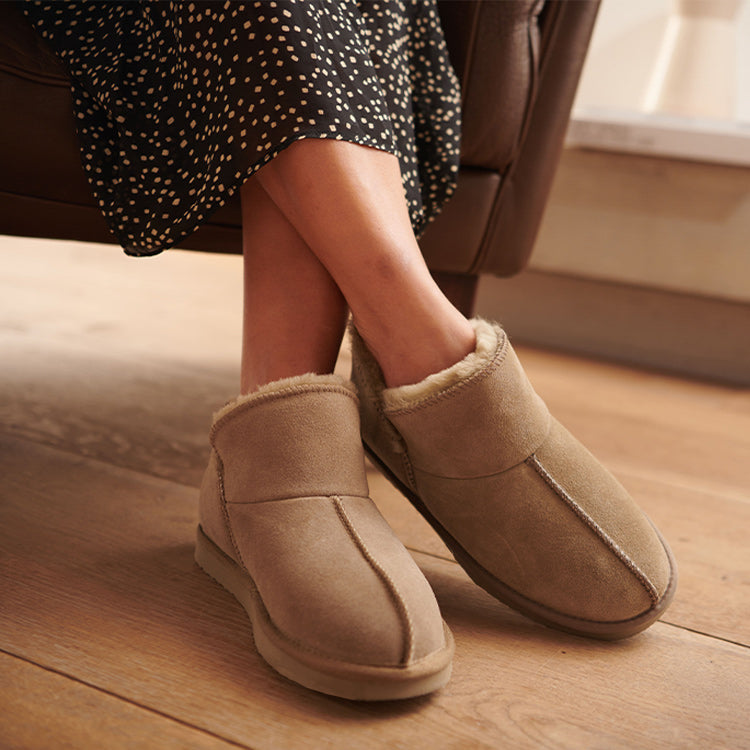 Vrouw op stoel met pantoffels dames suède look beige met warm imitatiebont